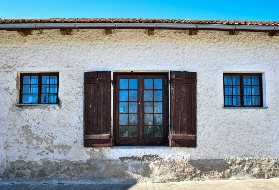 Fenêtres bois et volets sur une façade enduite