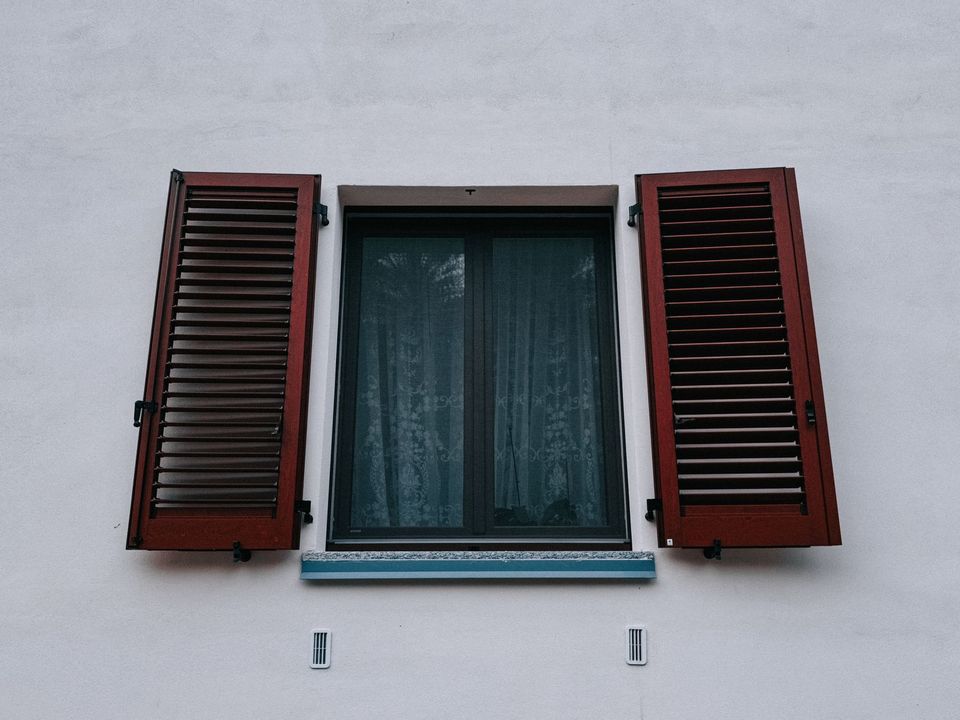 Fenêtre et volets bois sur façade claire