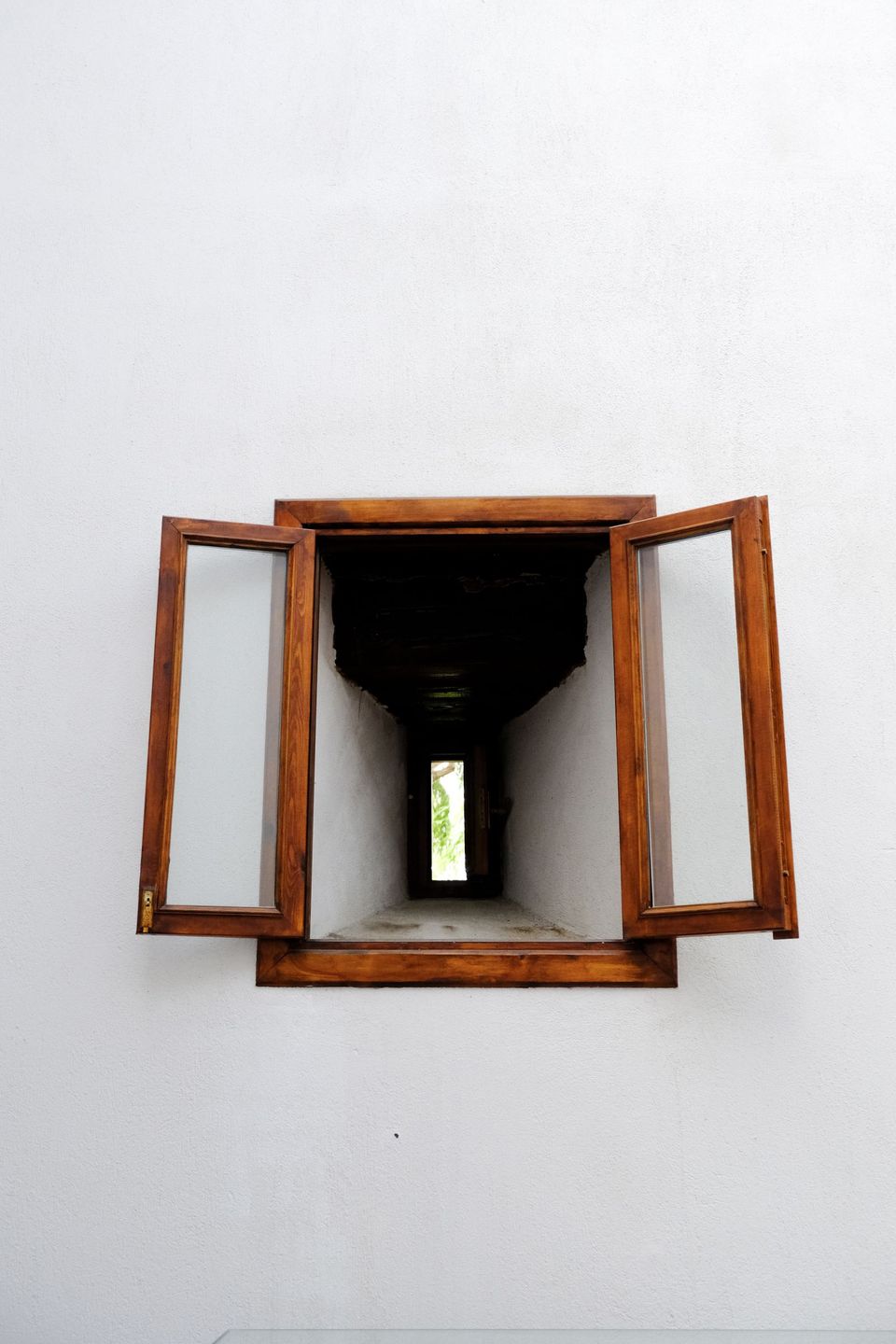 Fenêtre bois ouverte sur mur blanc